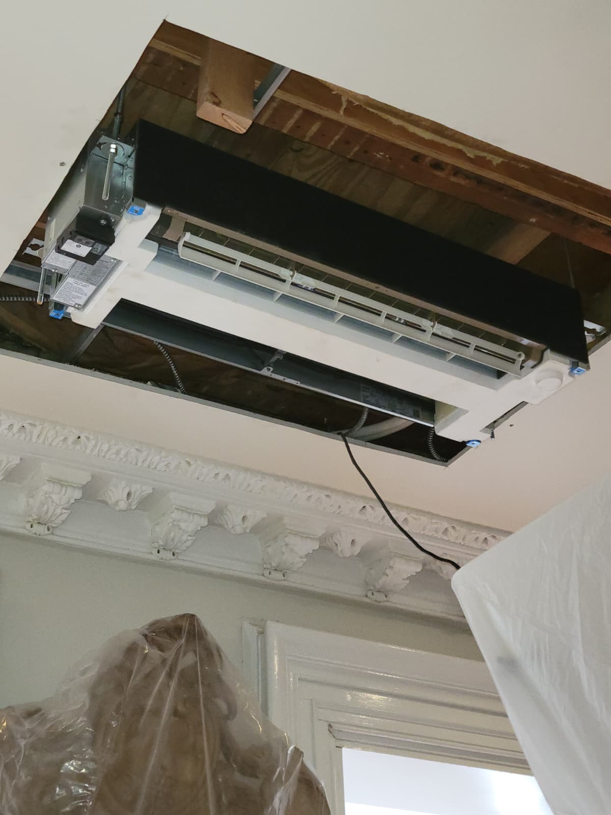 Ceiling cassette unit set into ornate prewar plaster ceiling