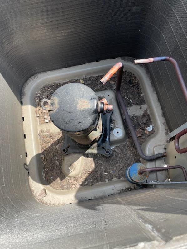 Burned compressor removed from inside condenser unit