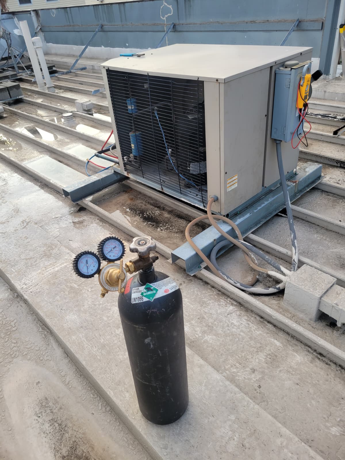 Commercial rooftop condenser on curb rails with nitrogen pressure test cylinder