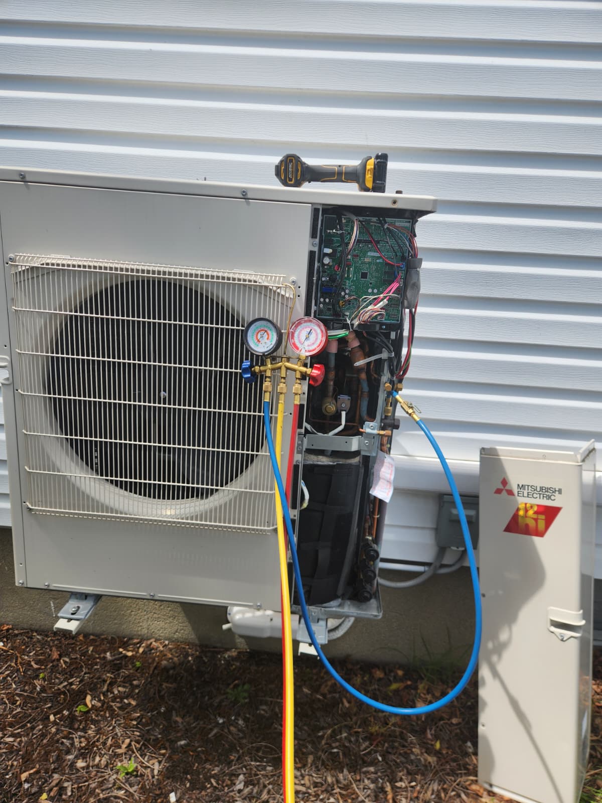 Mitsubishi Electric Ki mini-split outdoor condenser with refrigerant manifold gauges attached during service